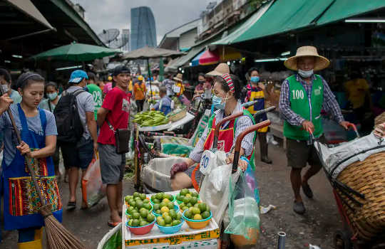 Vendors sell vegetables at a wet market in Bangkok, Thailand. 