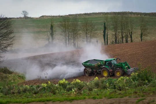Spreading lime on a field in Devon, England to improve soil quality. 