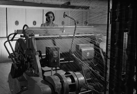A worker operates a warper at Montreal Cottons Ltd. in Valleyfield, Qué.