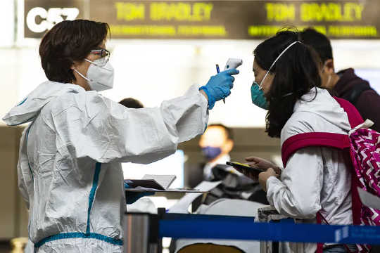 Travellers are screened and have their temperature checked at Los Angeles International Airport. 
