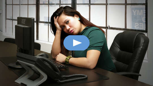 woman sitting at her desk looking worried