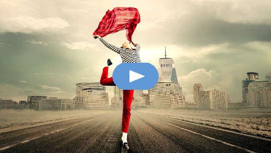 woman dancing in the middle of an empty highway with a city skyline in the background