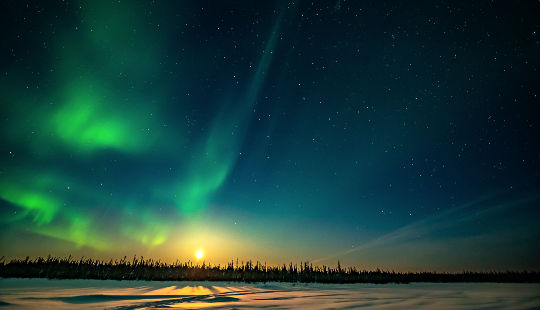 aurora borealis dancing over the moonrise