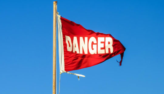 Red danger flag flapping in the wind