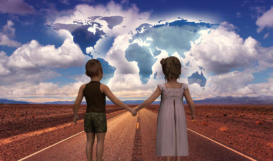 two children holding hands on a road with the world in front of them