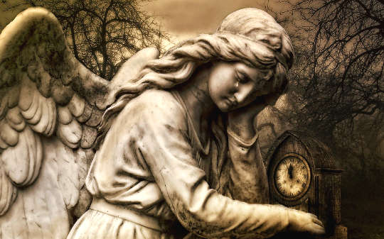 a statue of an angel holding a clock, with a tear falling from its eye
