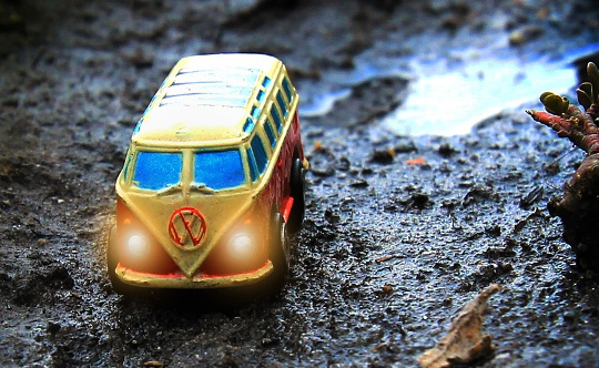 yellow Volkswagen van on a wet mountain terrain