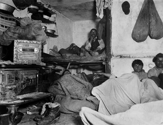 workers, jammed like sardines, living in a tenement