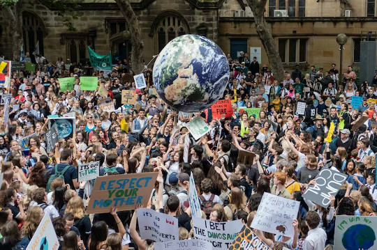 protestors holding up a big globe of Planet Earth