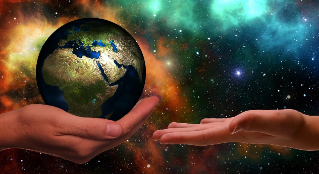 a hand holding planet earth offering to someone else's open hand