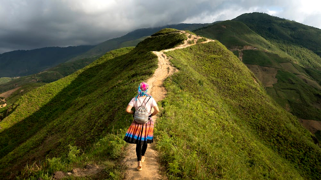 person walking alone on a mountainous path
