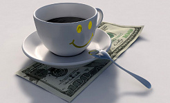 a smiley-face cup with coffee on top of a US $100 bill
