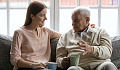 an older man speaking with a young adult over a cup of tea