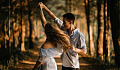 a couple dancing and twirling outside in nature