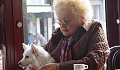 an old woman holding a dog on her lap