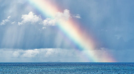 a rainbow shining down into the water
