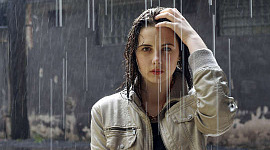 young woman standing under the rain