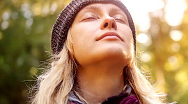 young woman with her eyes closed, face up to the sky